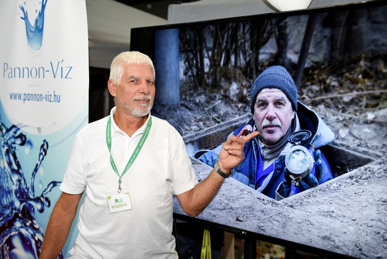 A Pannon-Víz Zrt. munkatársa a róla készült kép előtt állva